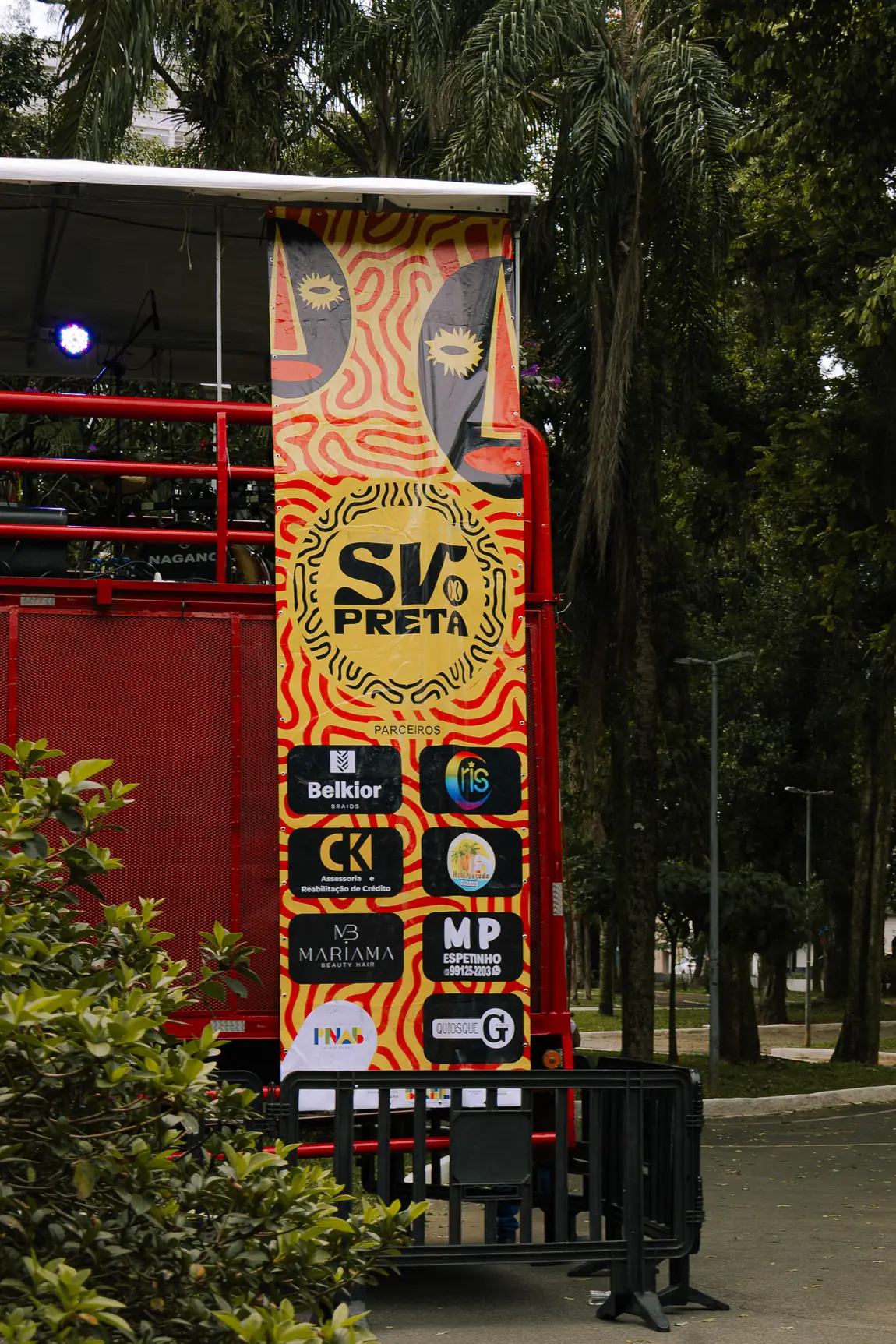 Torre do trio elétrico revestida com a marca SV Preta em meio às árvores