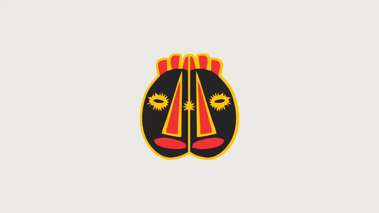 Emblema em forma de máscara, vermelho e preto com detalhes amarelos