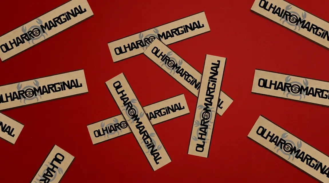 Etiquetas de papel com o logo do Olhar Marginal espalhadas sobre fundo vermelho
